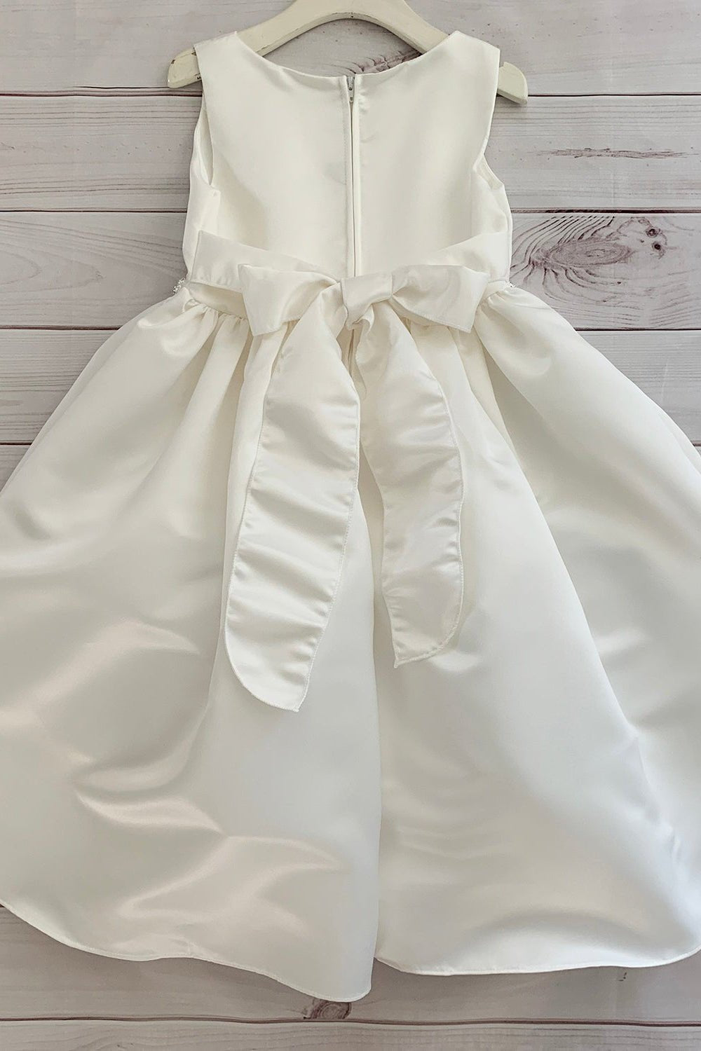 Ivory flower girl dress with a bow.