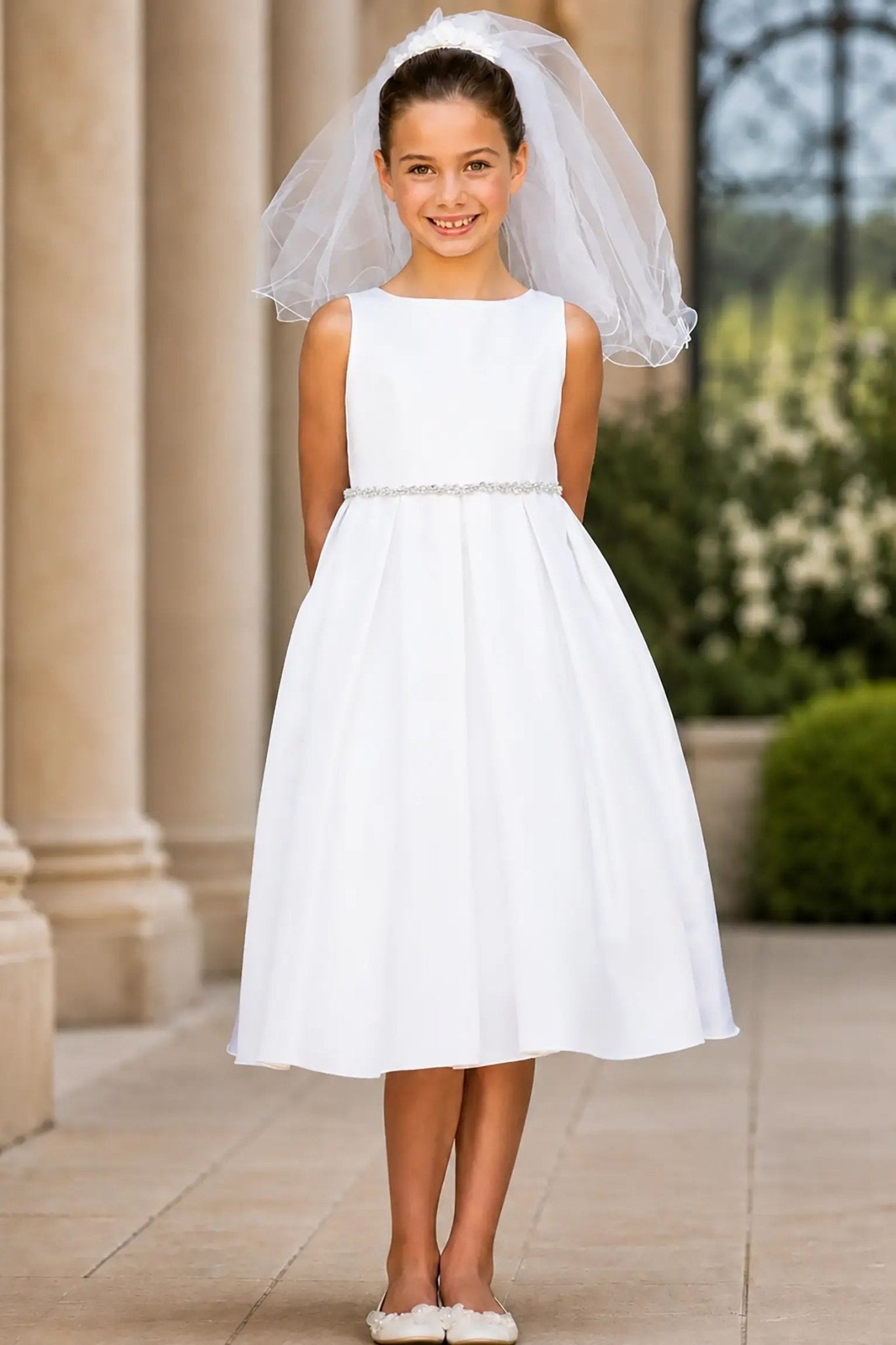 A white flower girl dress and pearl/rhinestone belt.