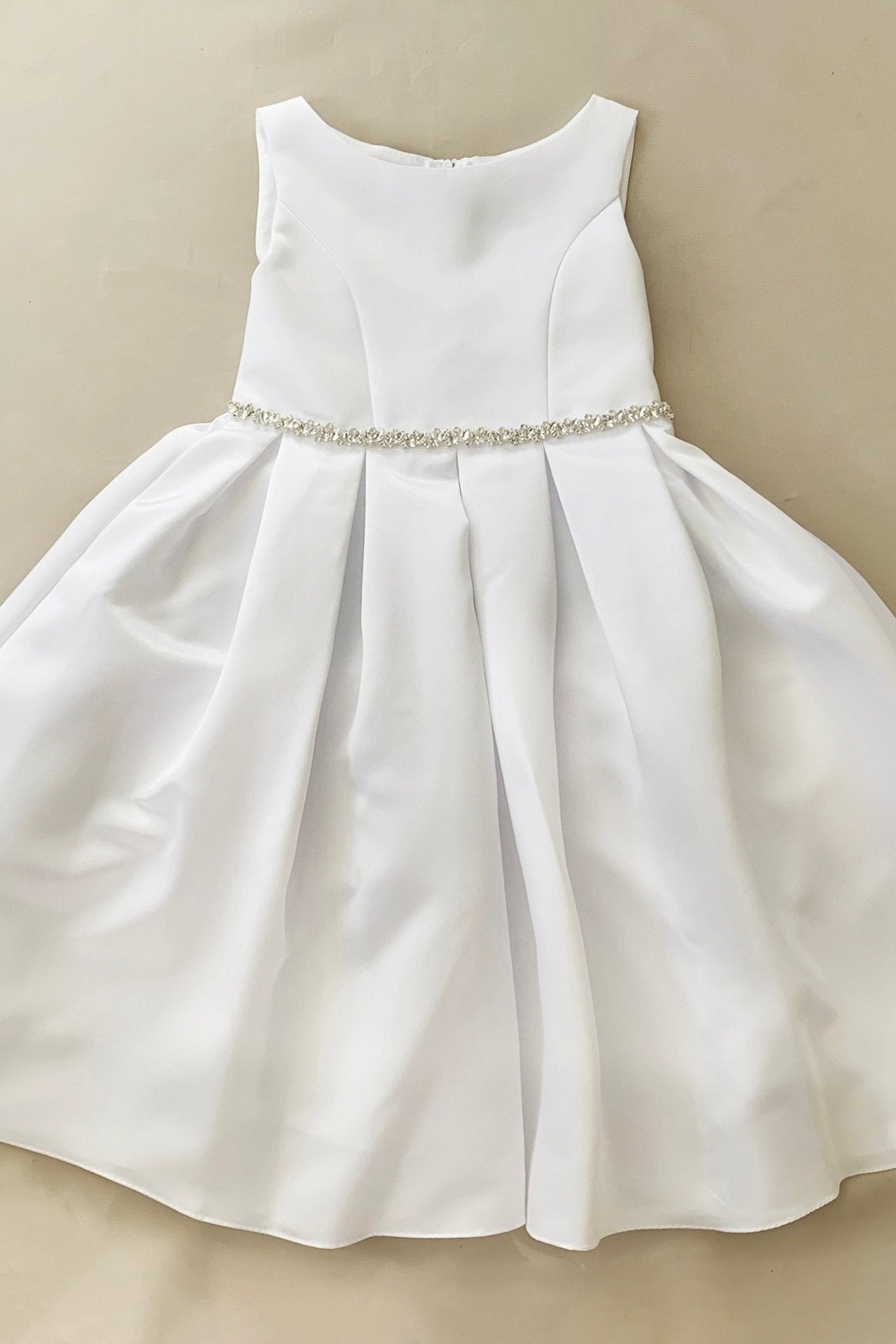 White dress with a beaded waistband on a beige background