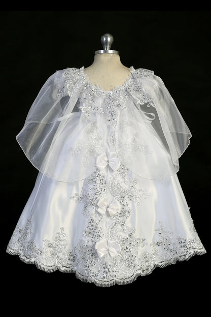 Detail of the white baptism dress showing rhinestone waist accent and split organza skirt.