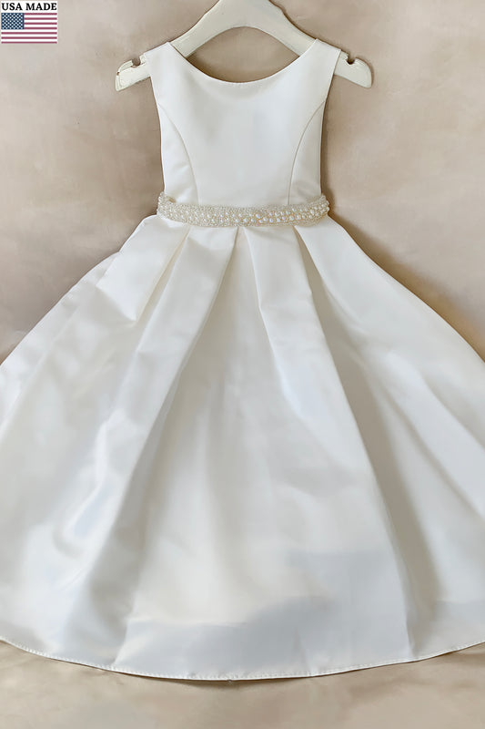 ivory flower girl dress with a pearl belt bow on a beige background