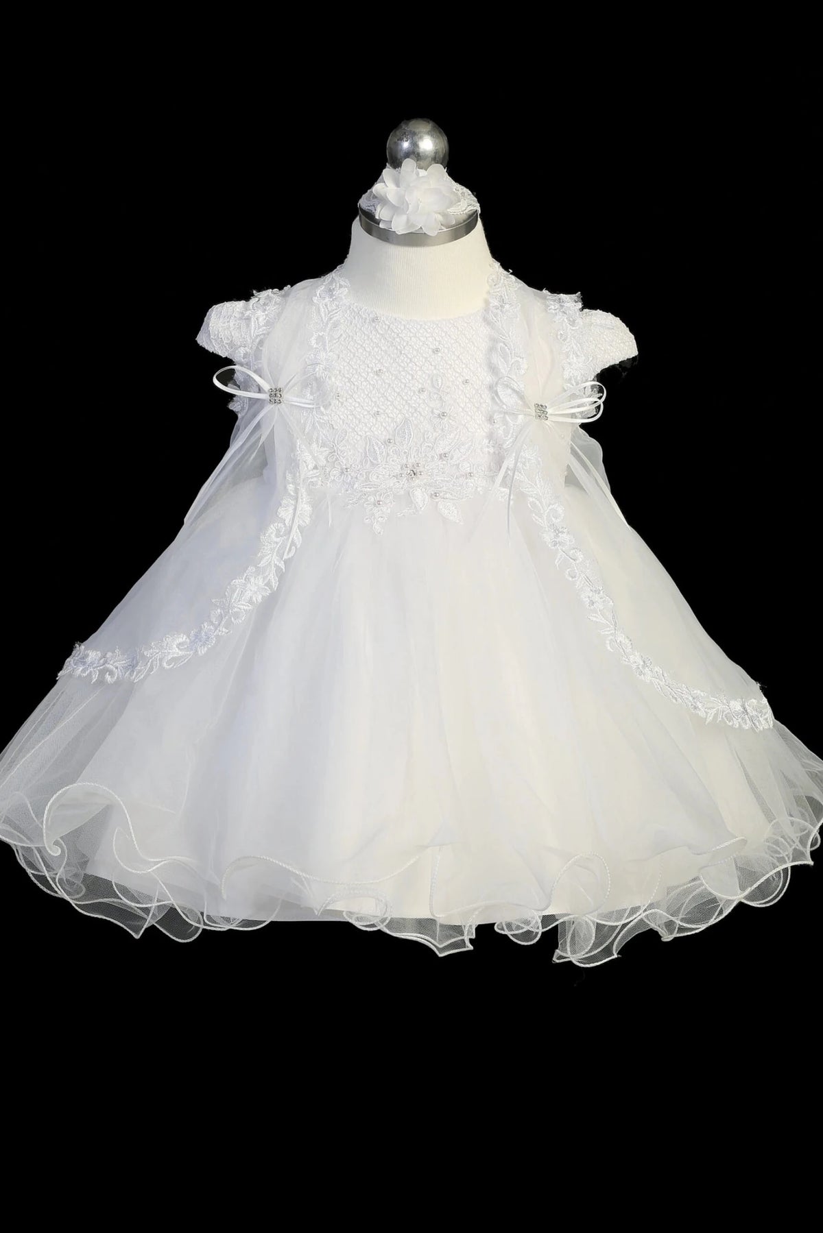 White christening dress with textured cap-sleeved bodice with pearl accents.