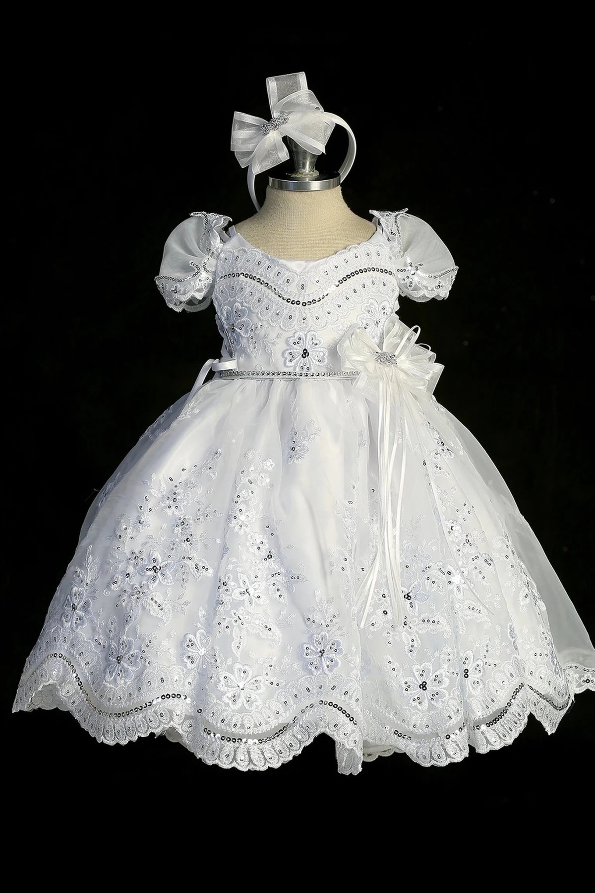 Detail of the white christening dress showing scalloped organza lace skirt.