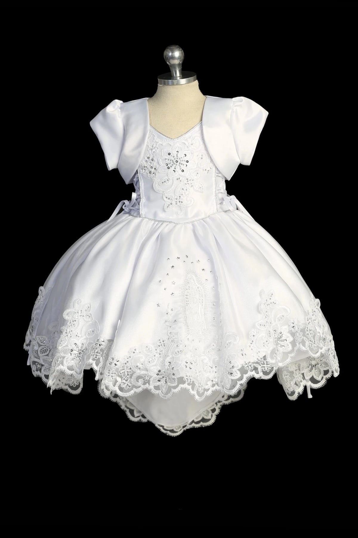 Detail of the white baptism dress showing removable outer skirt for a two-piece look.