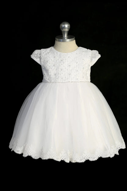 Detail of the white christening dress showing scalloped lace hem.