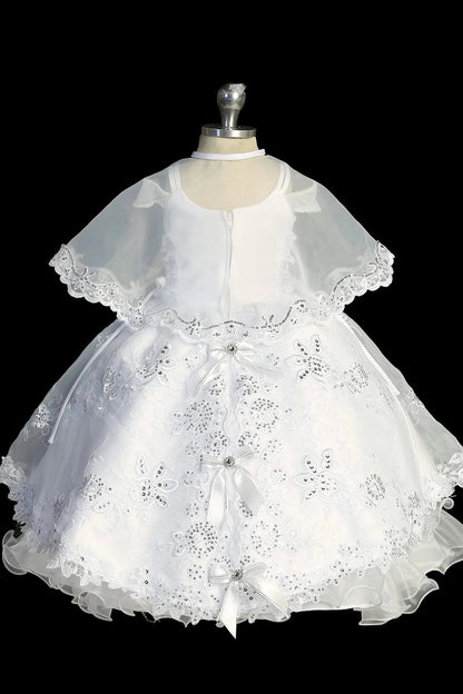 Another view of the white baptism dress with cap-sleeved lace bodice and a removable waist brooch.