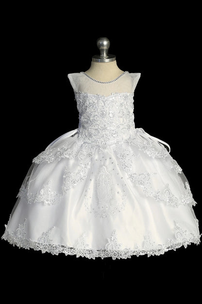 Detail of the white baptism dress showing Virgin Mary embroidery at the center of the skirt.
