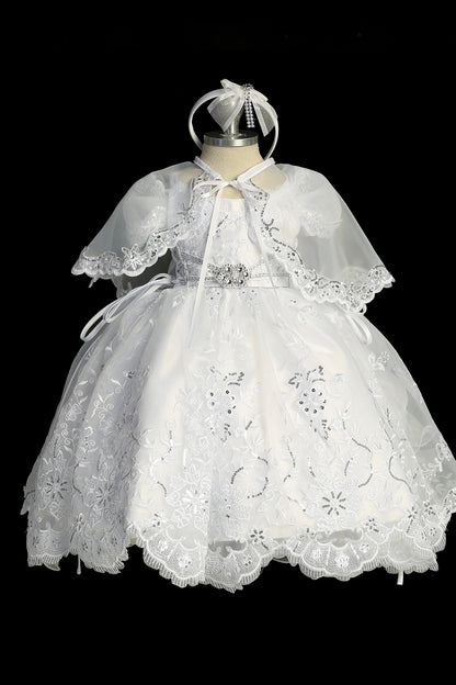 White baptism dress with short-sleeved lace bodice and a removable waist brooch.