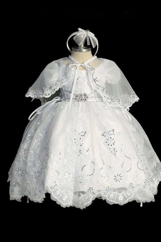 White baptism dress with short-sleeved lace bodice and a removable waist brooch.