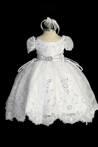 Detail of the white baptism dress showing scalloped hem with back ruffles and a large satin bow.