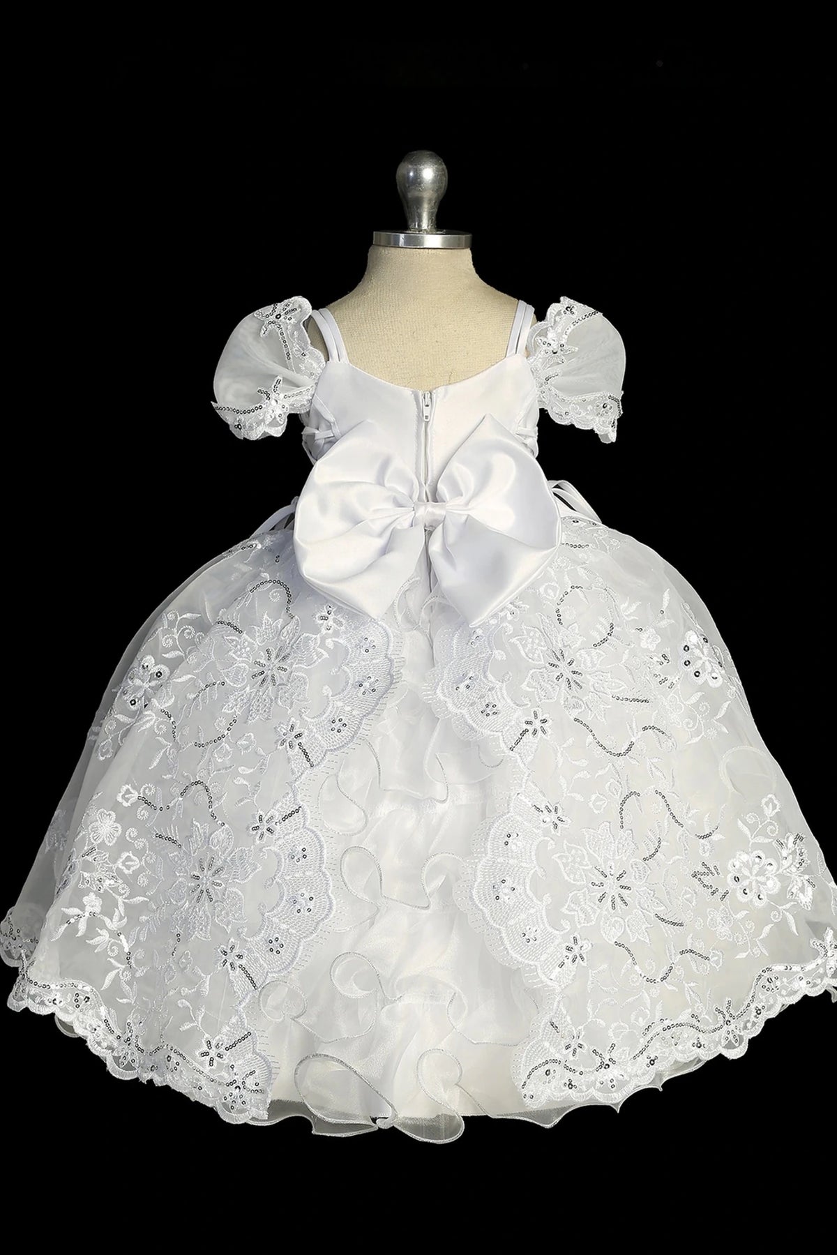 Another view of the white baptism dress with short-sleeved lace bodice and a removable waist brooch.