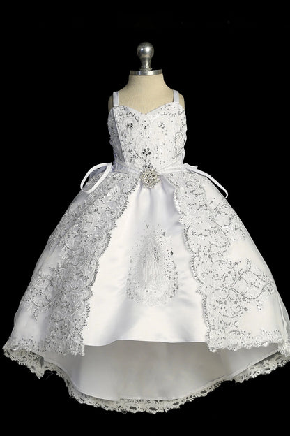 Detail of the white baptism dress showing high-low skirt with Virgin Mary embroidery and bow accents.
