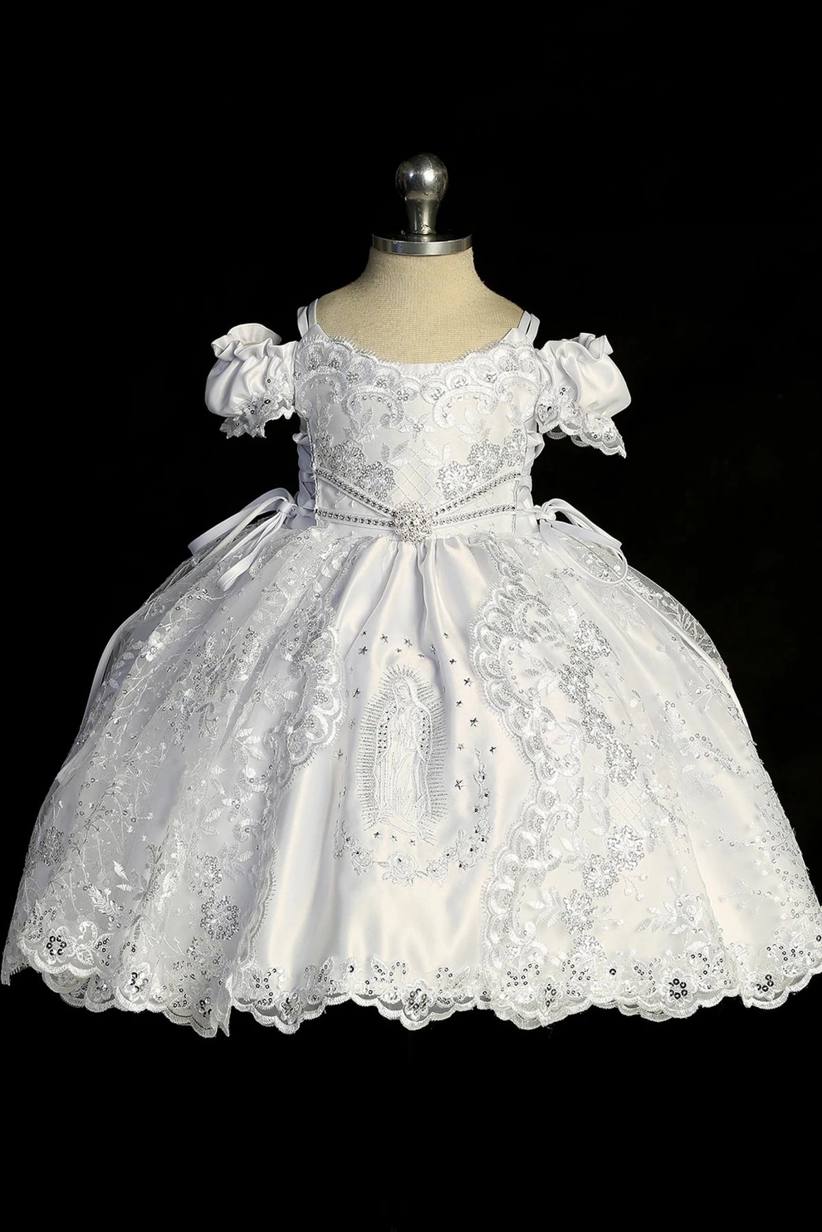 Detail of the white baptism dress showing scalloped organza lace overlay and Virgin Mary skirt embroidery.