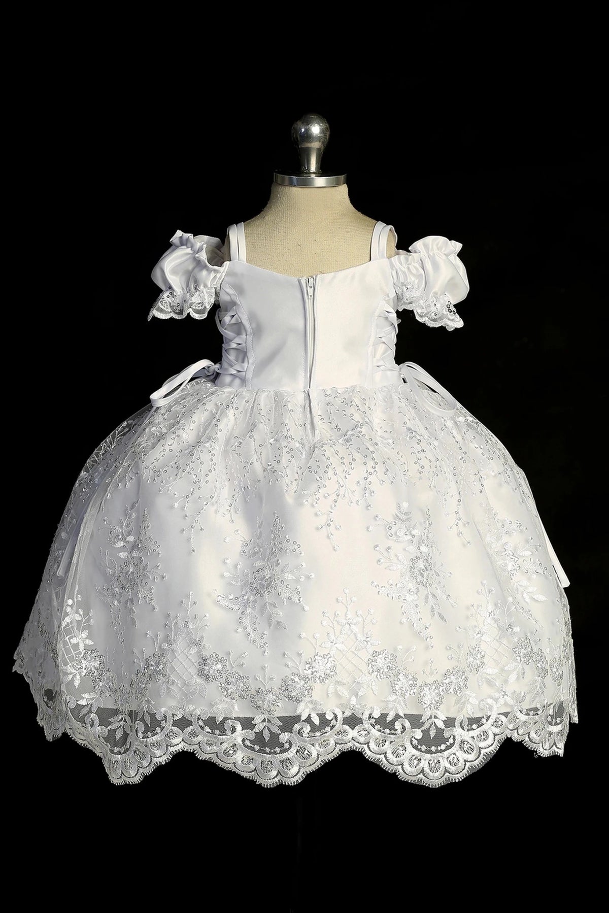 Back view of the White baptism dress showing satin sash ties and scalloped lace hem.