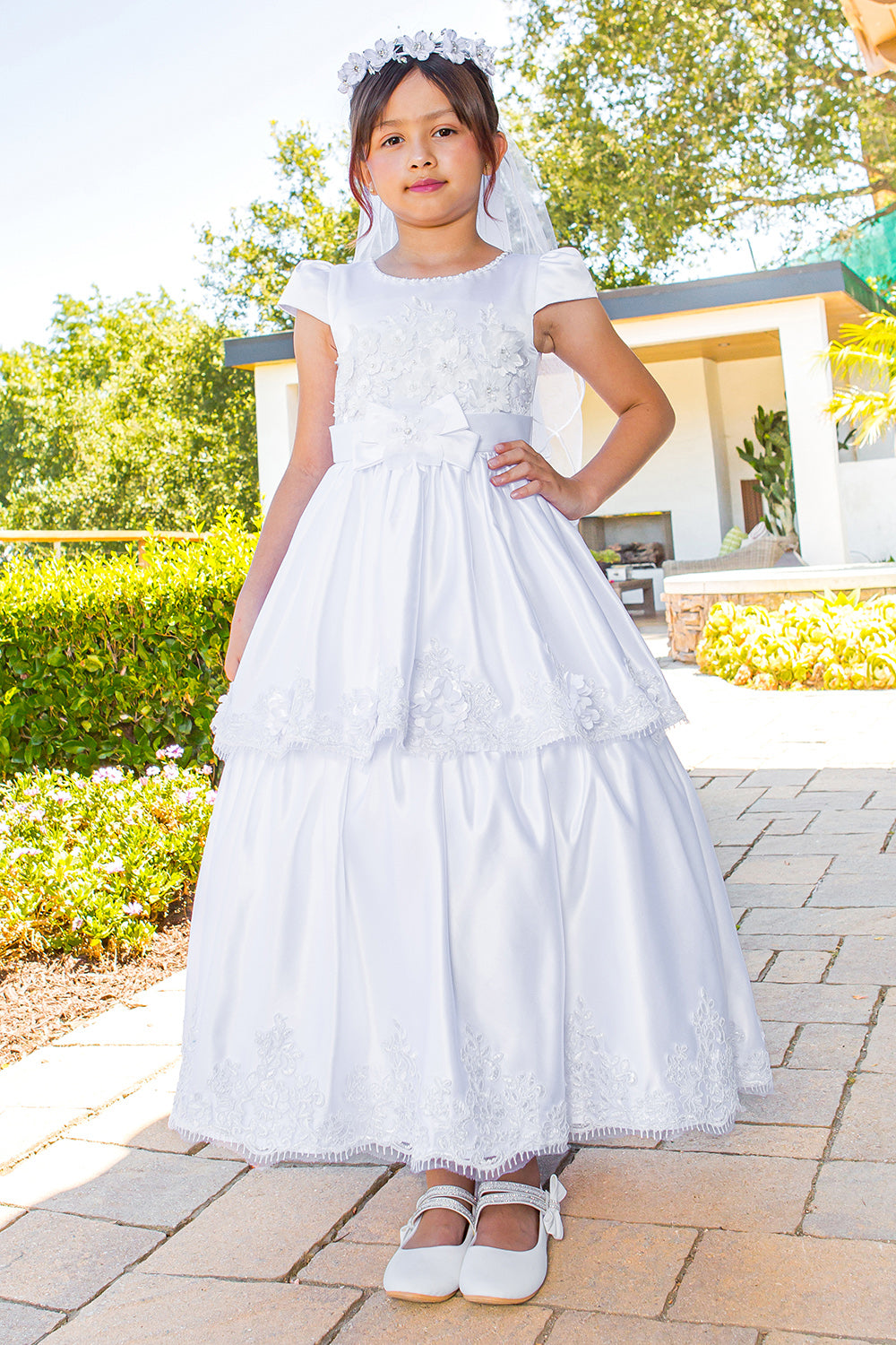 Elegant Illusion Top satin Cap Sleeve Embellished Skirt Communion Dress with Beads, Laces and Back Satin Sash - front view of girl wearing dress with one hand on hip