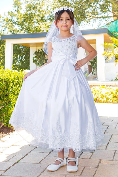 White communion dress with a satin waist bow and scalloped lace skirt.