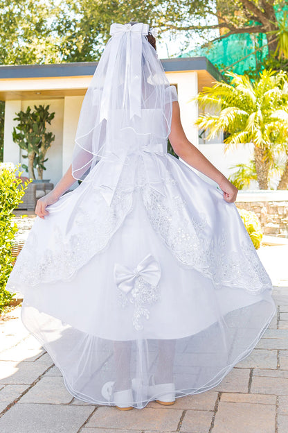 Back satin sash forms a broad bow on this White communion dress.