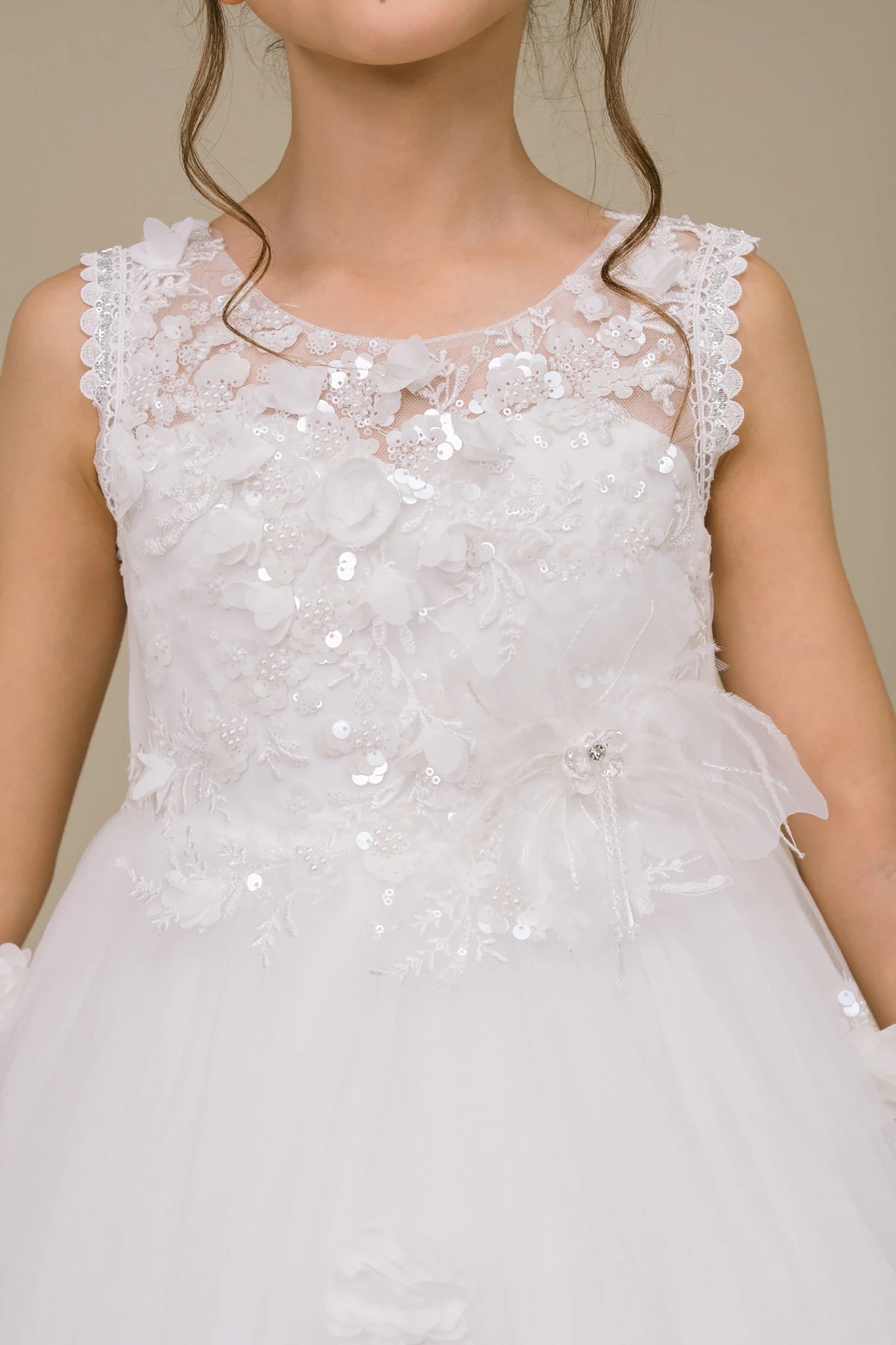 close up a white floral applique pearl sequin lace flower girl dress on a beige. Also suitable as a communion dress.