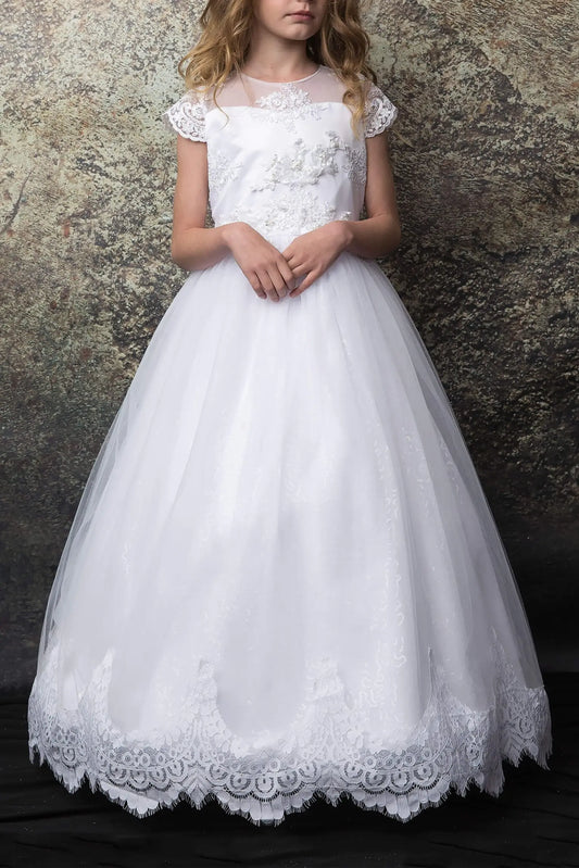White lace dress worn by a young girl against a textured wall.