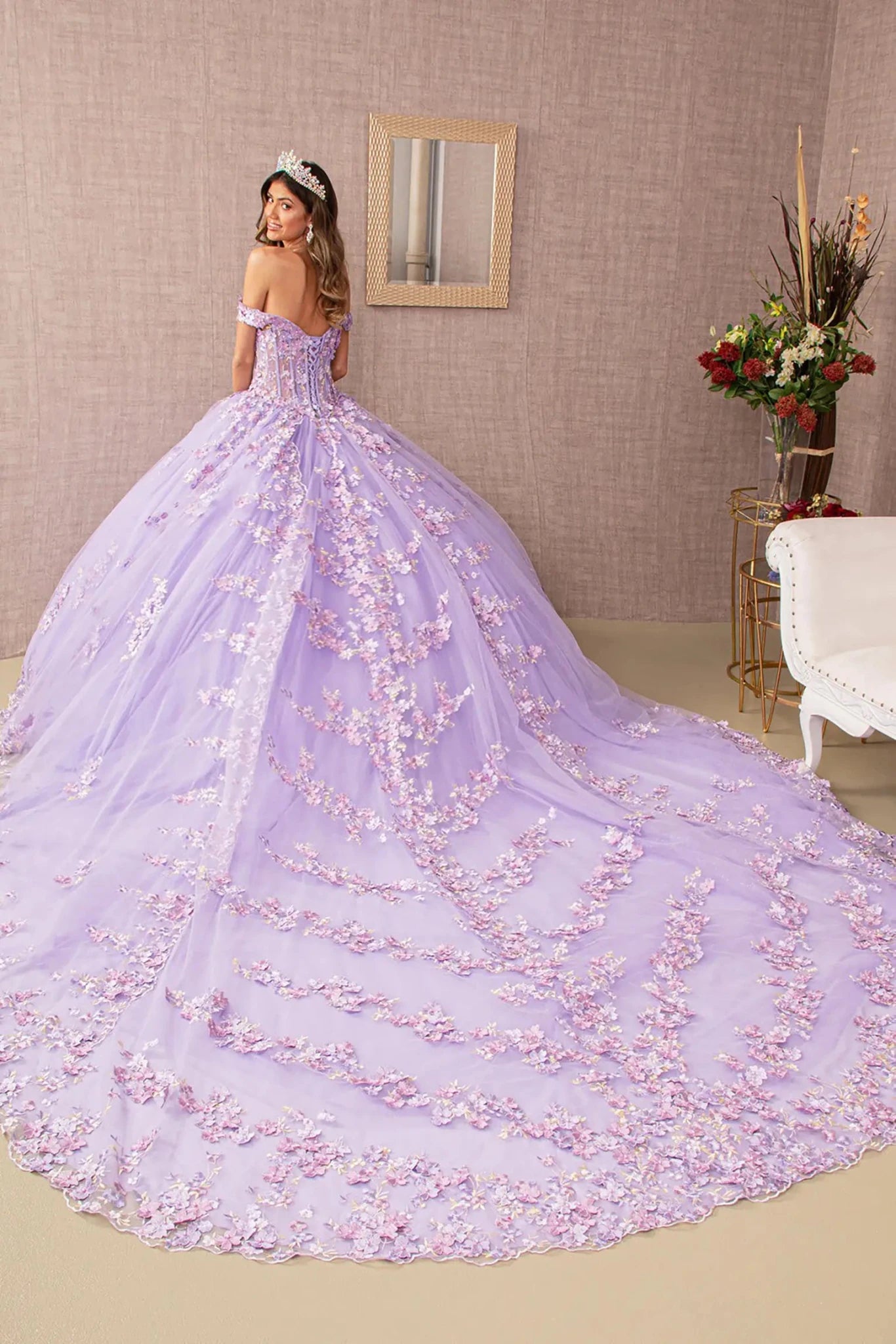 Woman in a lilac extra long train ball gown with floral details in an elegant room.