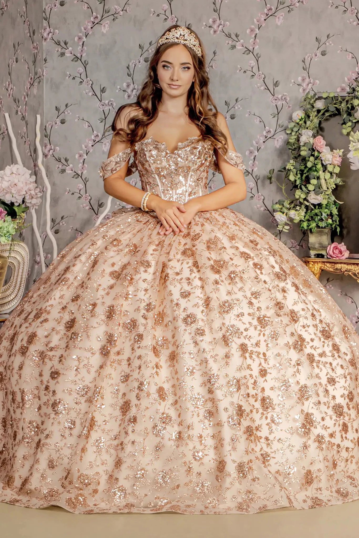 Girl in a gold floral and sequined champagne ball gown with a decorative background