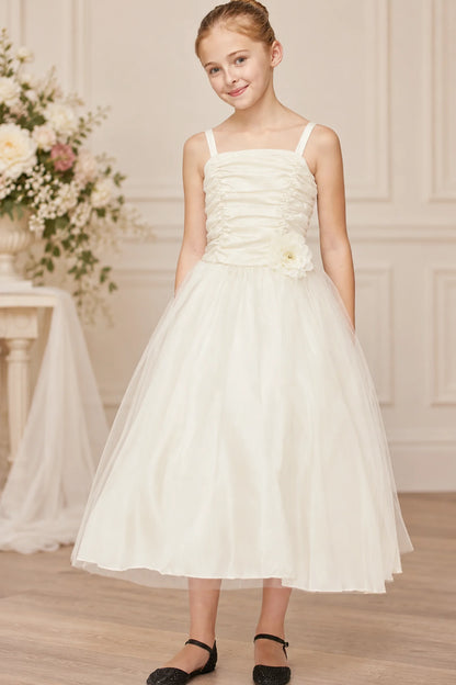offwhite sleeveless A-line flower girl dress with a ruched bodice, floral detail on the side, and a full tulle skirt
