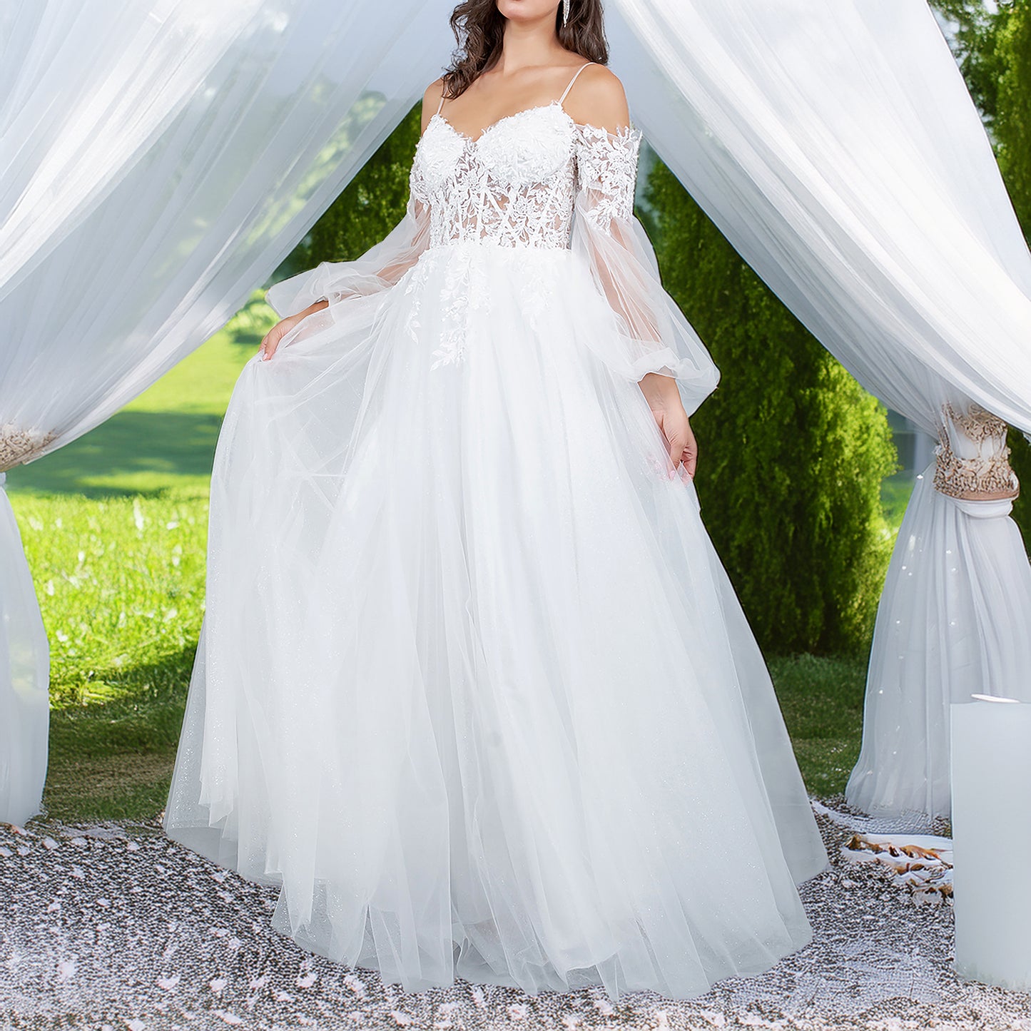 White wedding dress with lace detailing and sheer sleeves in a garden setting