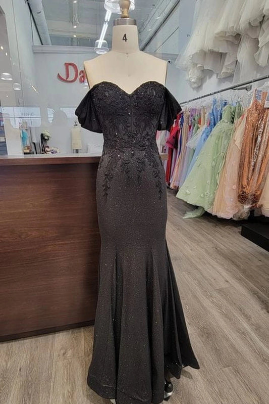 Featuring a floor-length skirt, this Black prom dress is shown in full view.
