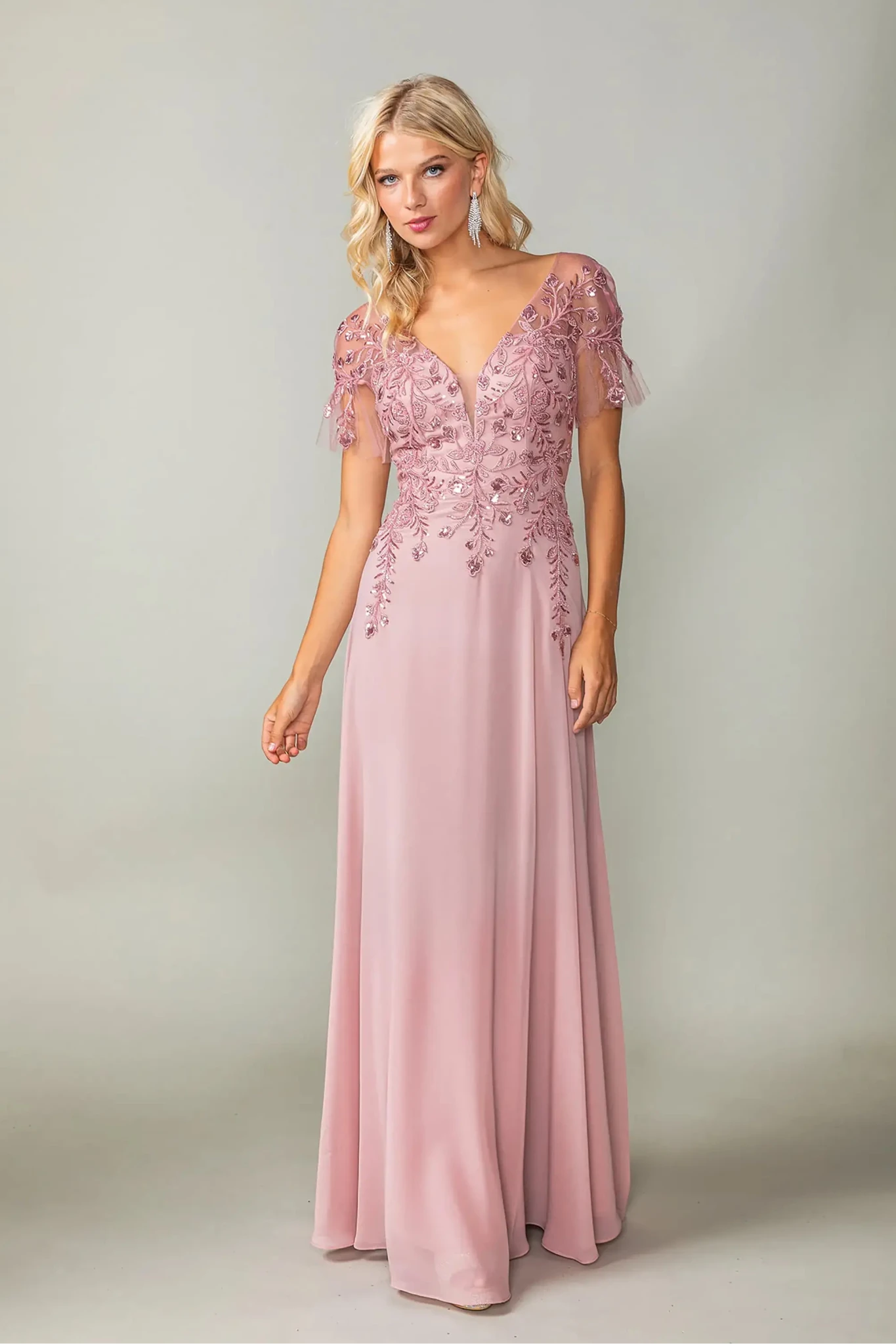 Woman in Dusty Blue prom dress with applique and flutter sleeves.