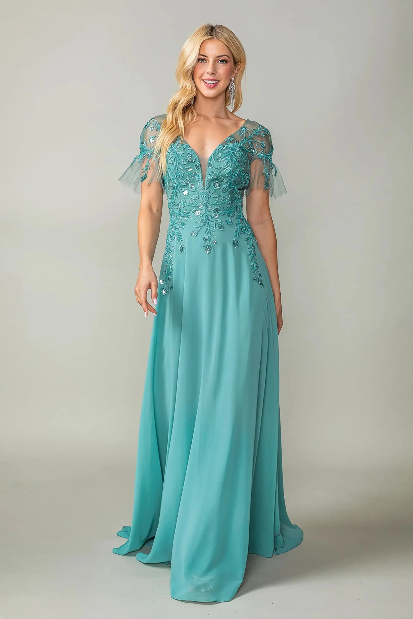 Woman in Sage prom dress with applique and flutter sleeves.