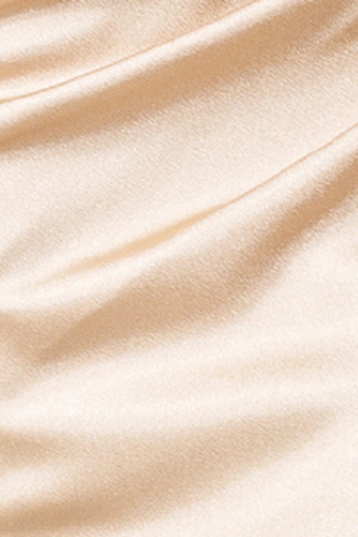 Featuring textured embellishments, this Champagne prom dress is shown in detail.