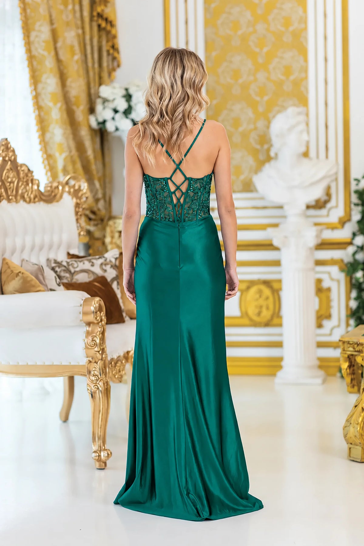 a floor-length emerald green evening gown with a lace-up open back and lace bodice, 