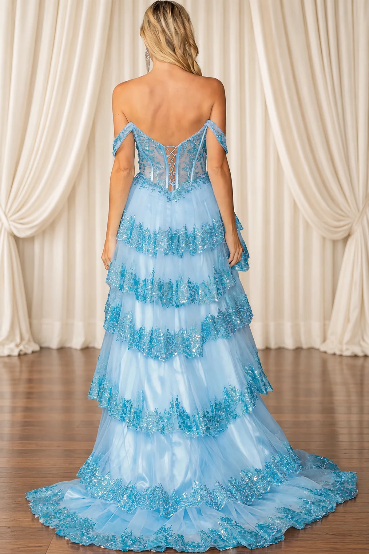 blue off-the-shoulder evening gown with a lace corset back and a tiered tulle skirt with floral lace trim