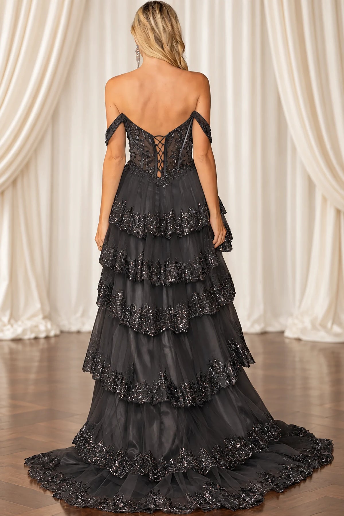Sheer back and cascading ruffles complete the Black Beaded Prom Dress.