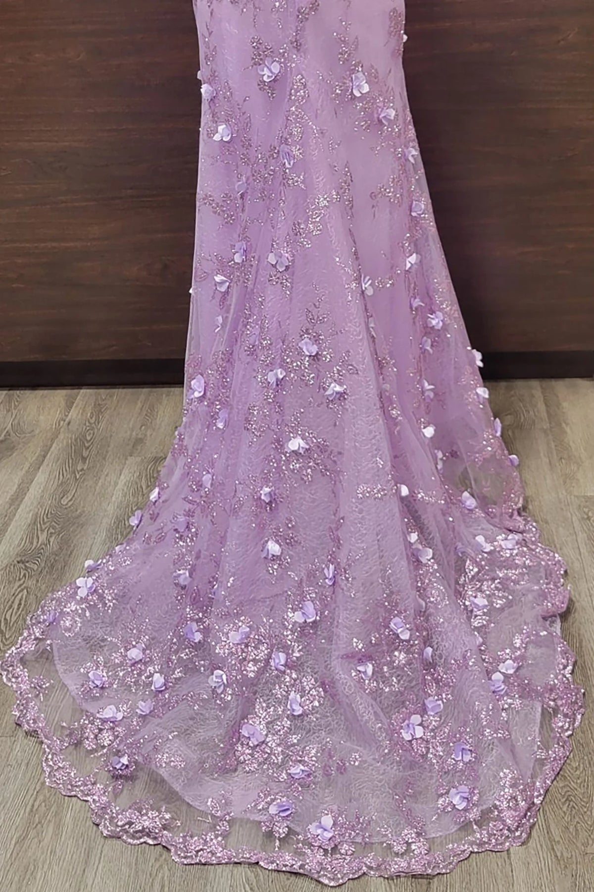 Appliquéd skirt detail highlights the Lilac Off-the-Shoulder Floral Applique Prom Dress.