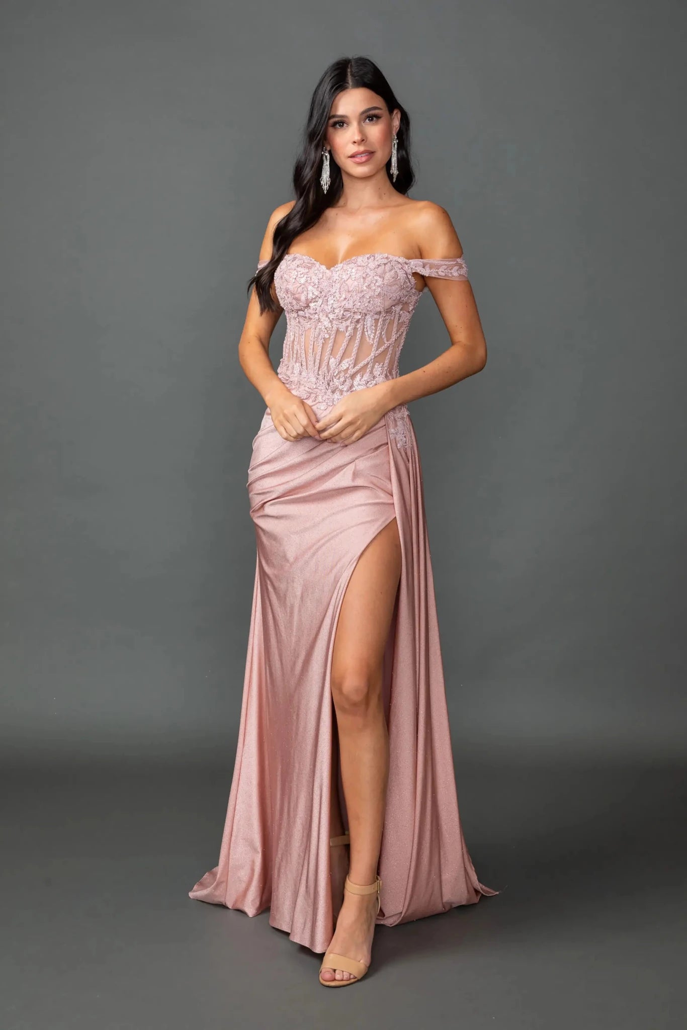 Woman in Rose Gold off-shoulder glitter prom dress with corset and slit.