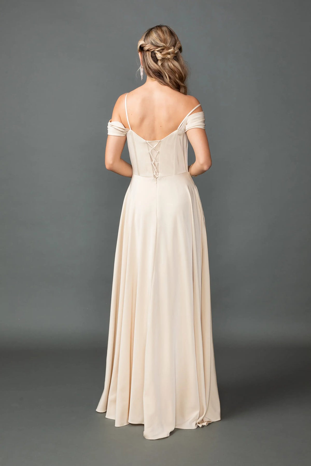 Revealing soft shoulder bands and a flowing skirt, this Champagne prom dress is shown from the back.