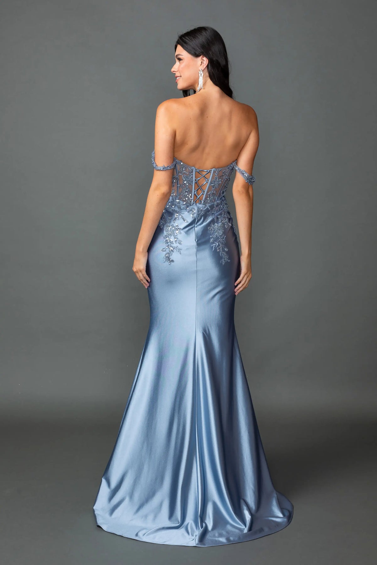 Revealing embellished detailing around its open back, this Dusty Blue prom dress is shown from the back.