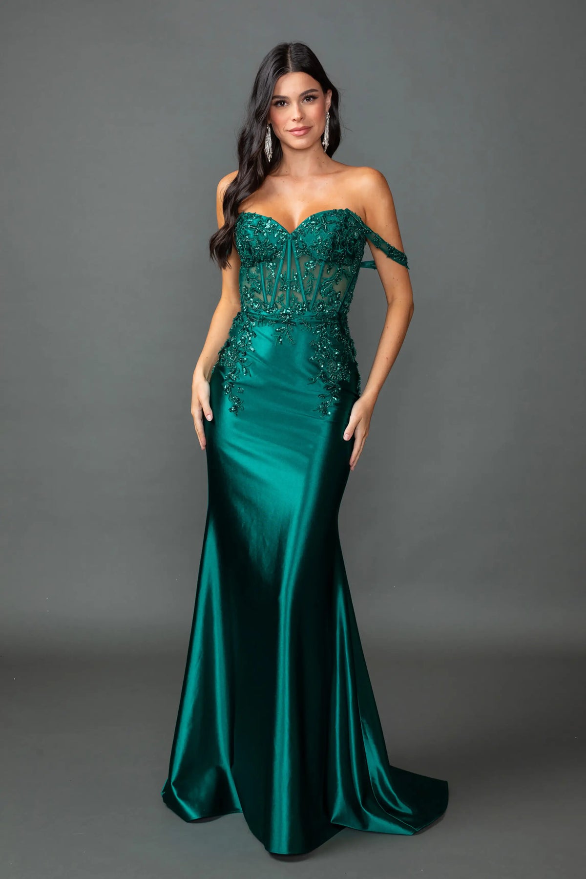 Showing beaded corset detailing above its satin skirt, this Hunter Green prom dress is shown in full view.