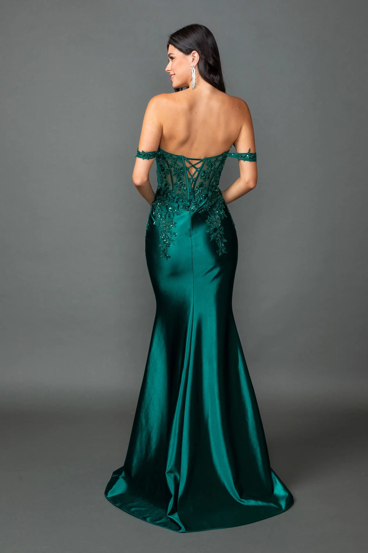 Revealing embellished detailing around its open back, this Hunter Green prom dress is shown from the back.