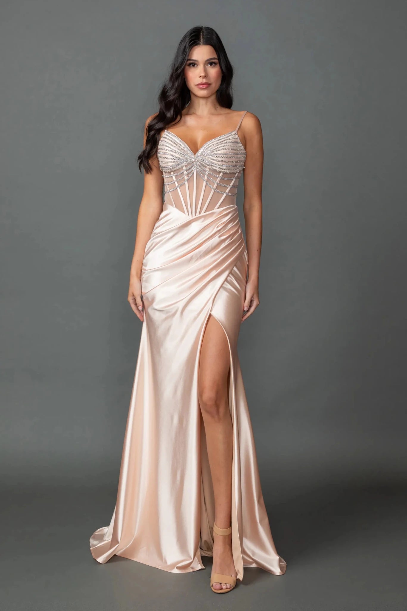 Woman in Champagne satin prom dress with beaded corset bodice and dramatic side slit.