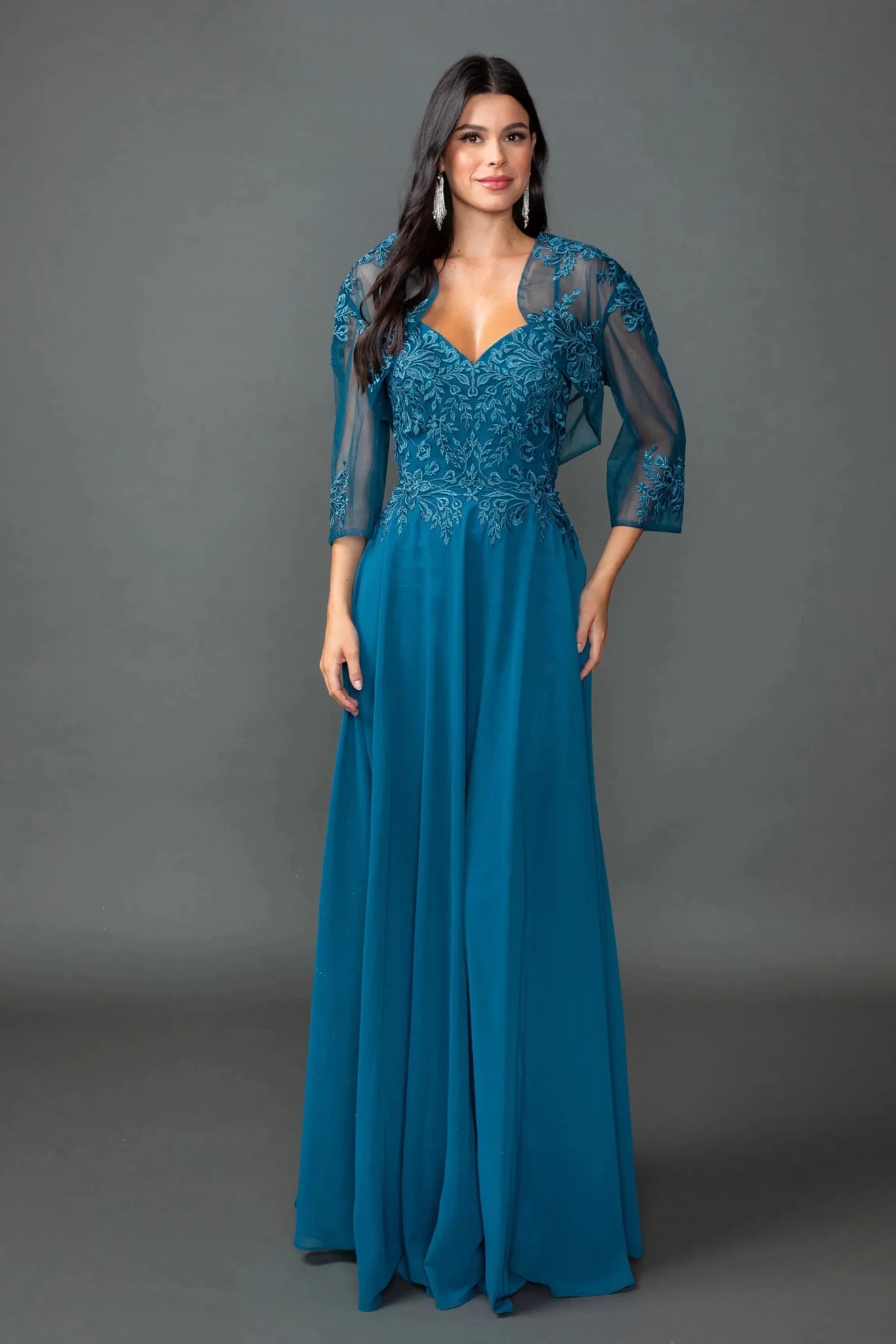 Woman in Teal chiffon prom dress with embroidered bodice and bolero jacket.