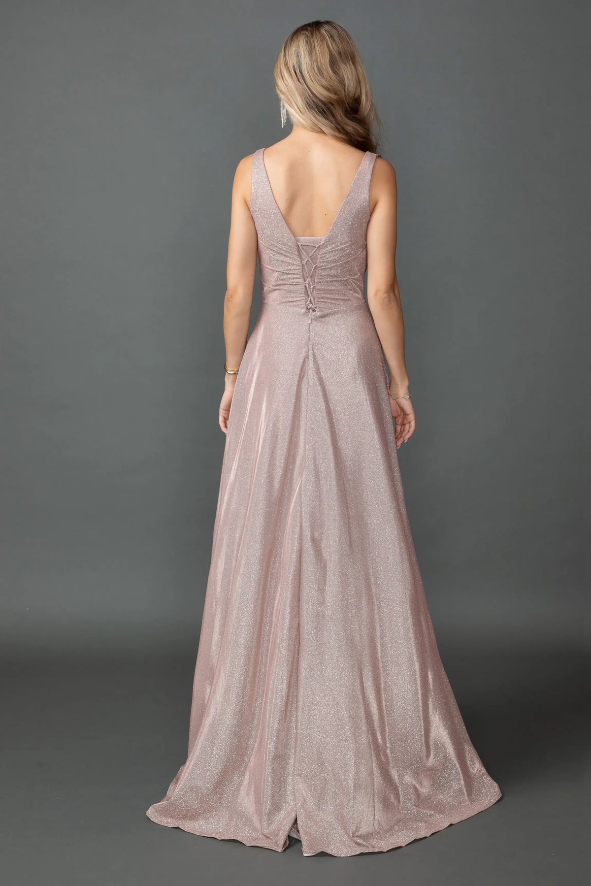Revealing a low V-back above its full-length skirt, this Rose Gold prom dress is shown from the back.