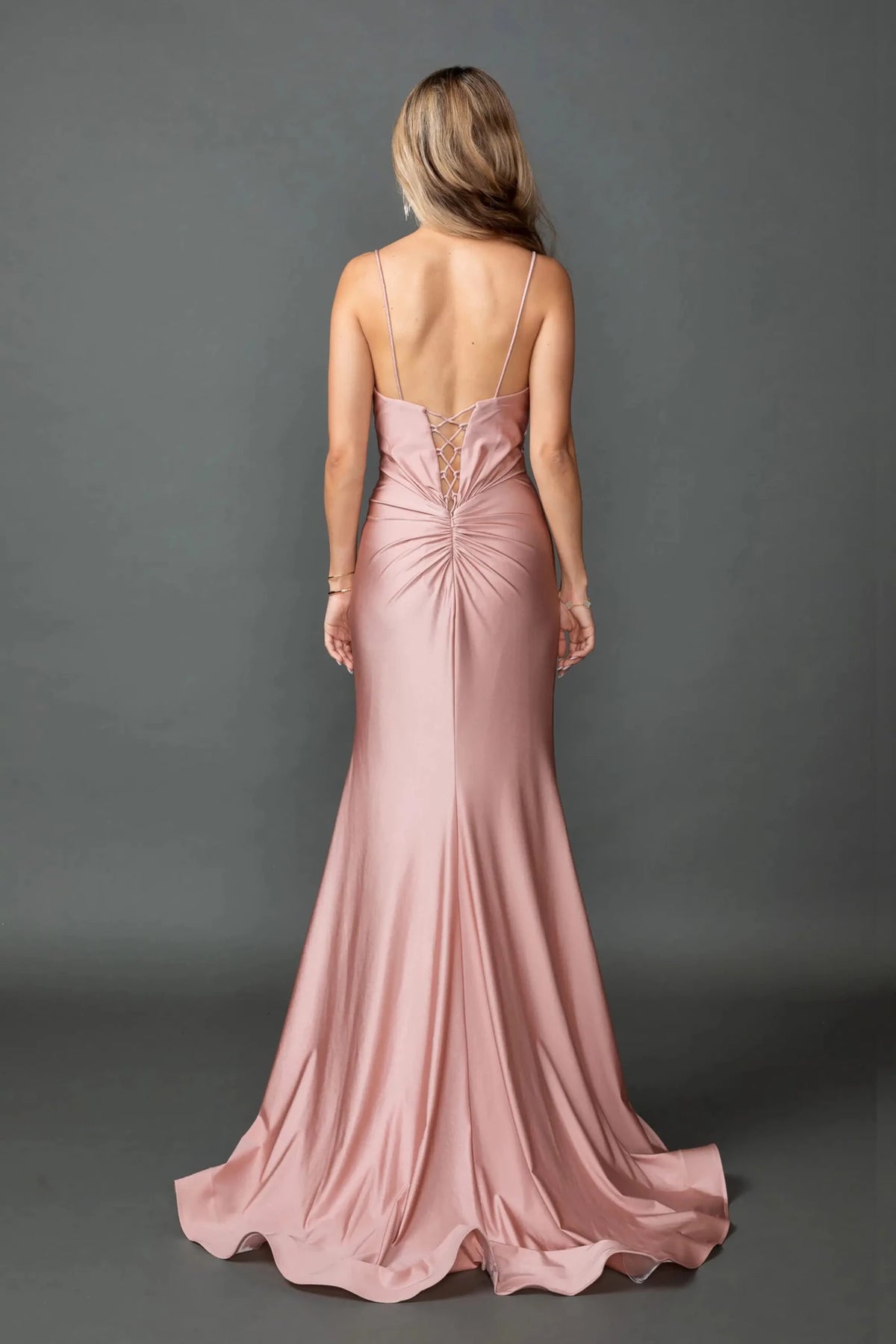 Revealing a lace-up bodice above its trailing hem, this Dusty Pink prom dress is shown from the back.