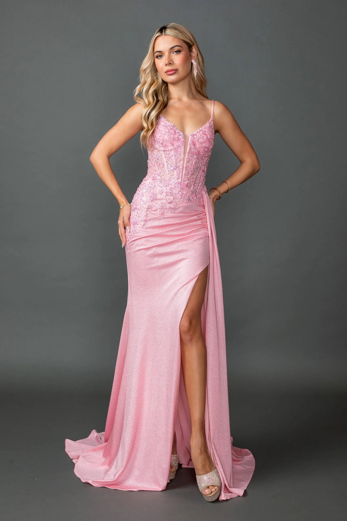 Showing beaded corset detailing and a high slit, this Pink prom dress is shown in full view.