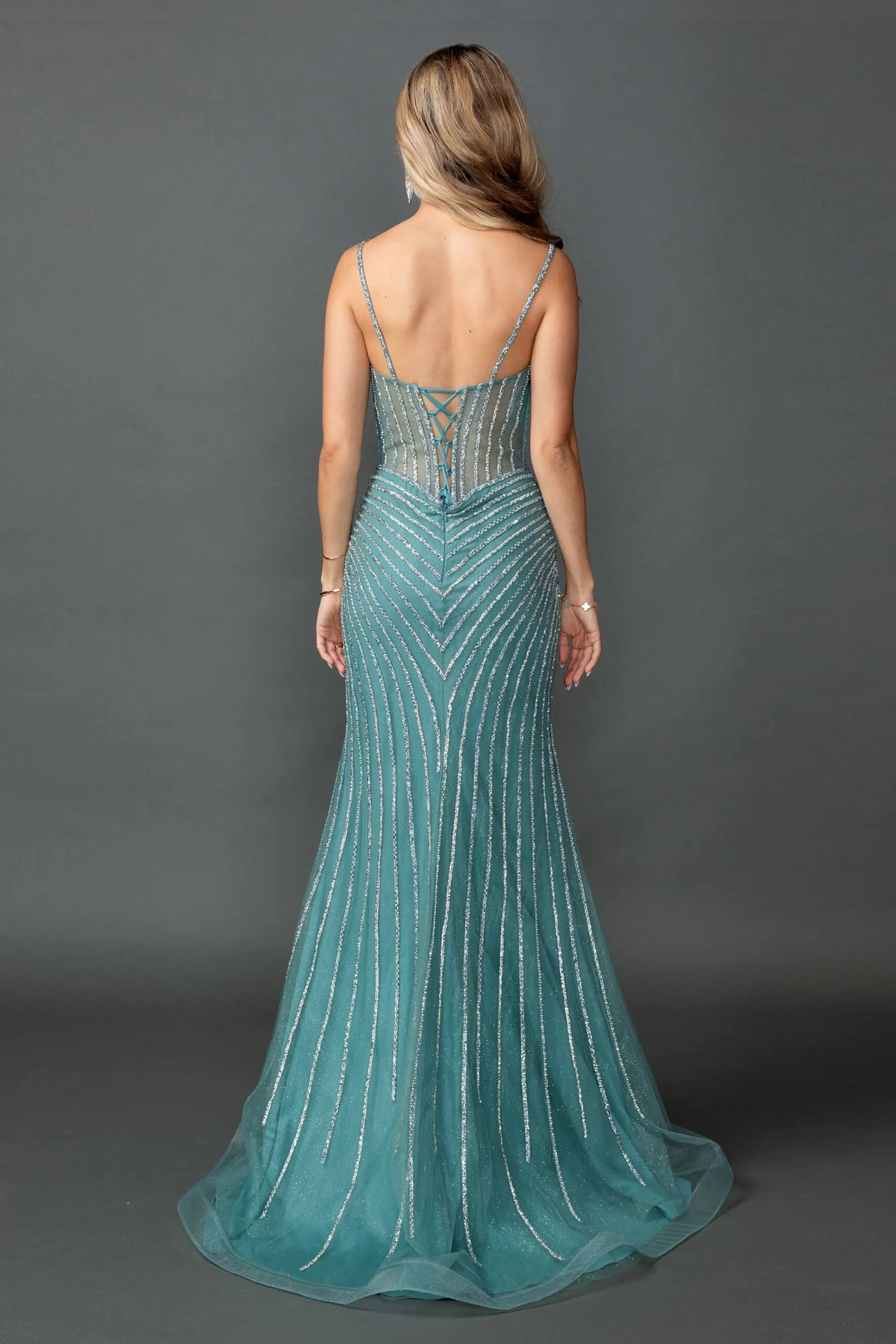 Revealing vertical sequin lines flowing into its train, this Lake Blue prom dress is shown from the back.