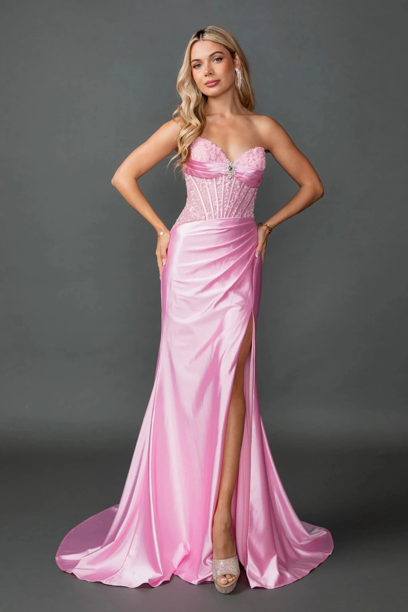 Woman in Pink strapless satin prom dress with beaded corset and slit.