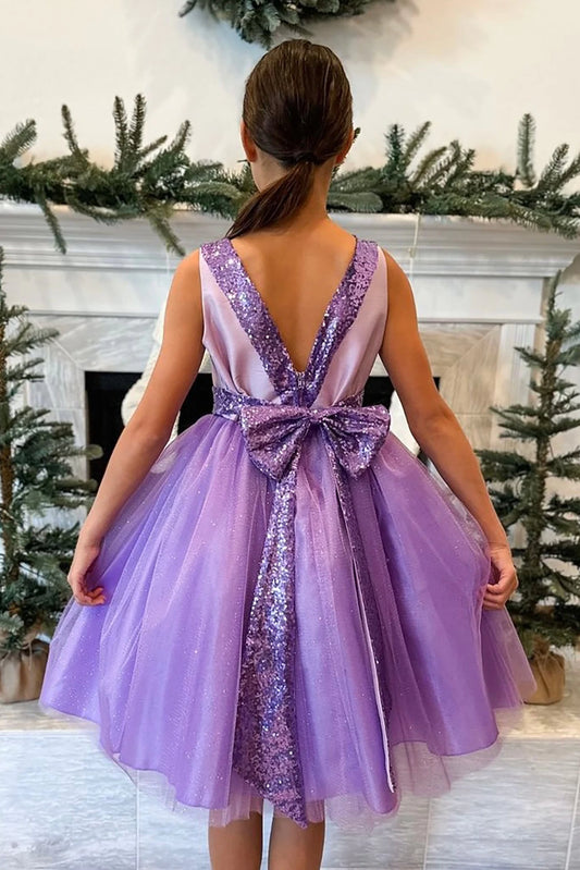 A lilac sequin flower girl dress with a bow.