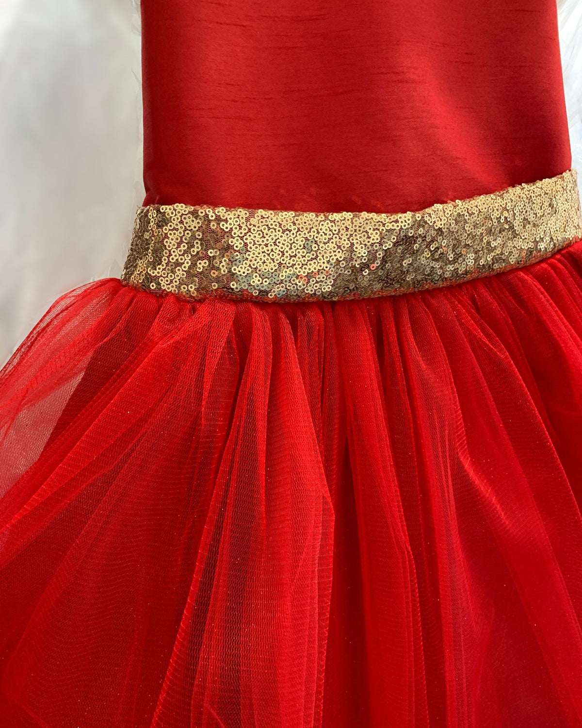Red flower girl dress with a gold sequined waistband.