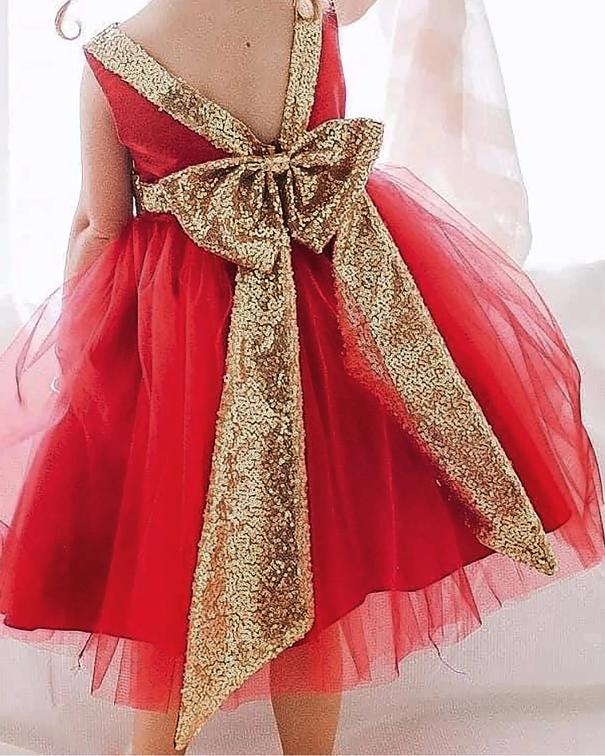 Red flower girl dress with a large gold bow.